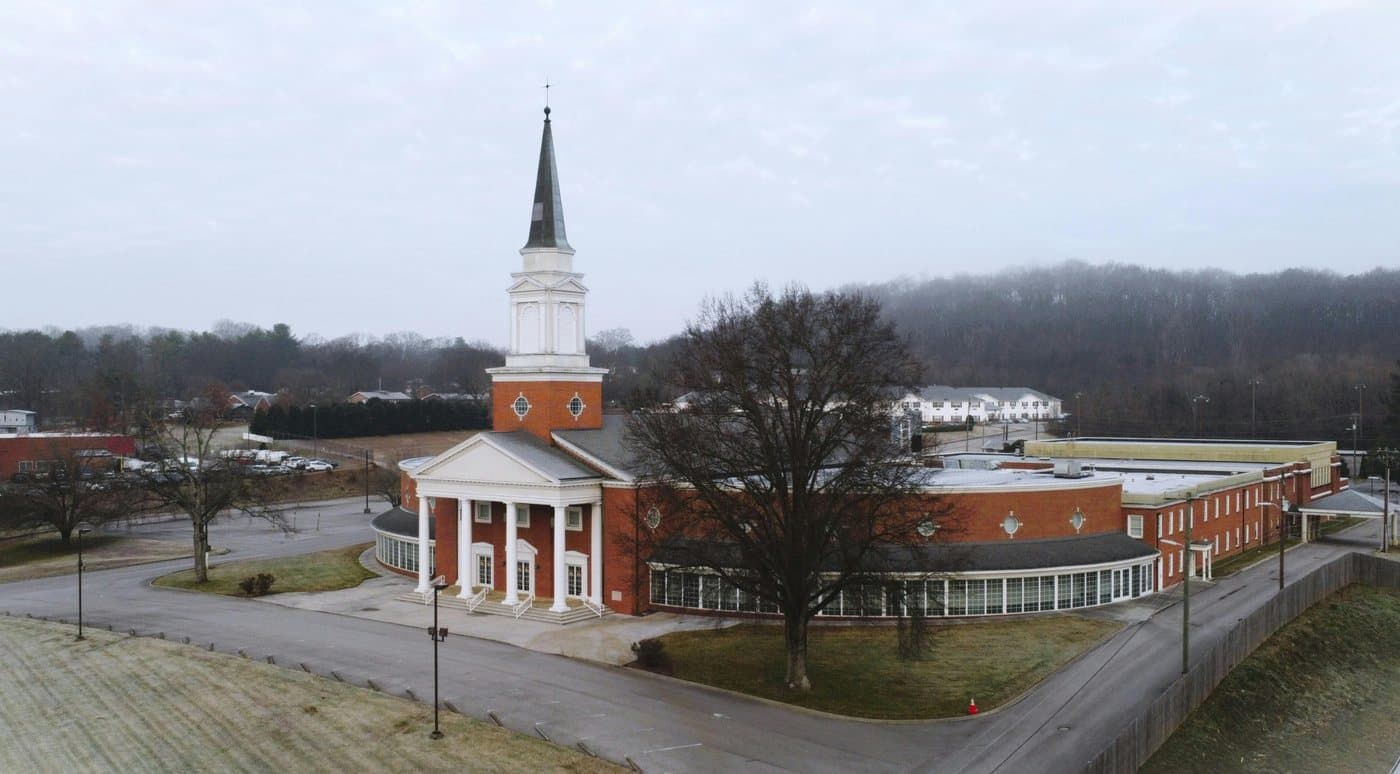 A large red-brick church with white columns and a tall steeple on a grey winter morning in Middle Tennessee