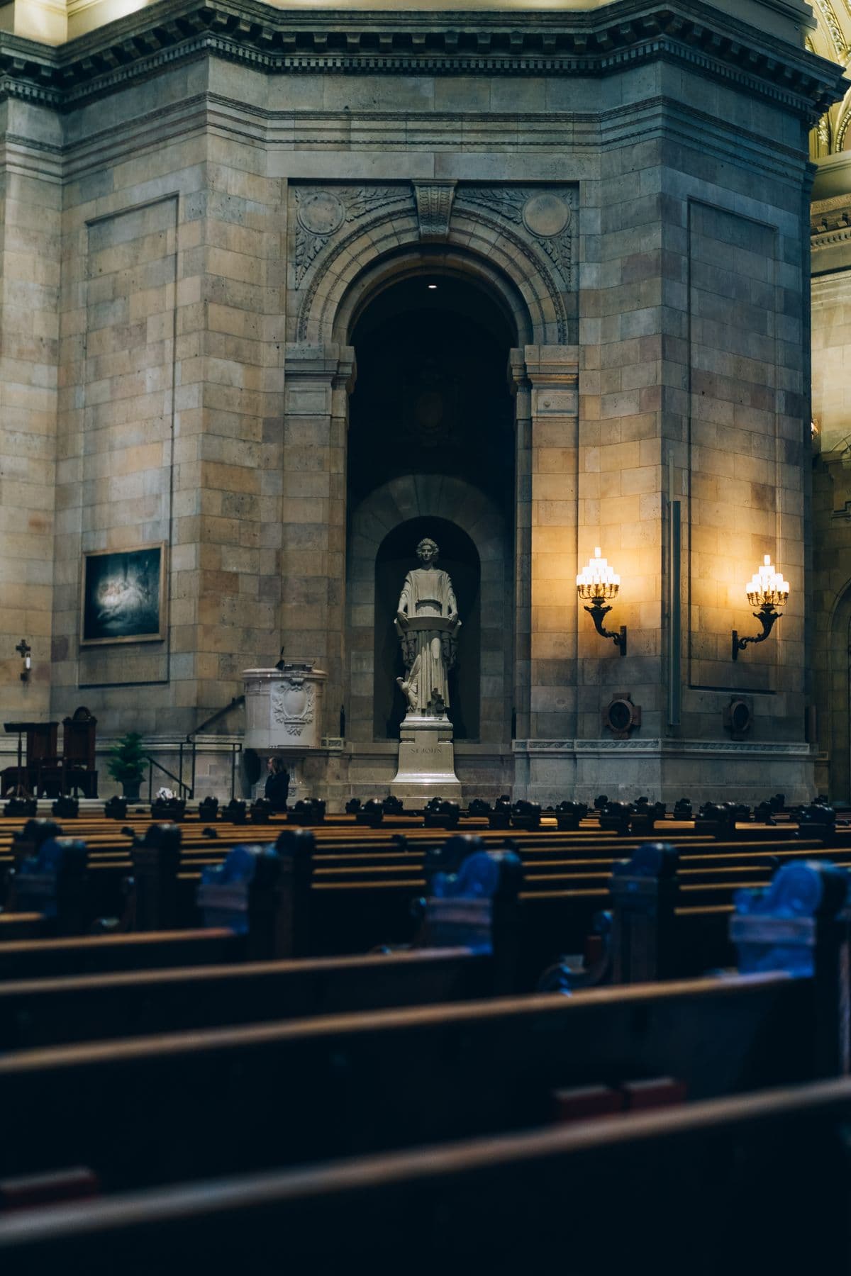 The dim, empty interior of a stone church — rows of vacant pews in soft, warm light — a reminder that harm can occur within the spaces meant to feel sacred