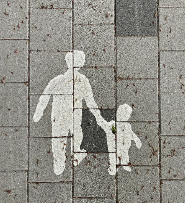 Painted silhouettes on stone of an adult and child holding hands