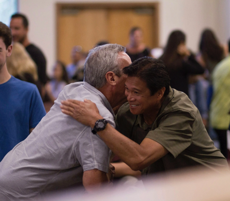 People embracing warmly in a community setting
